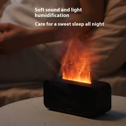 Black humidifier on table emitting warm light and mist with person resting in background