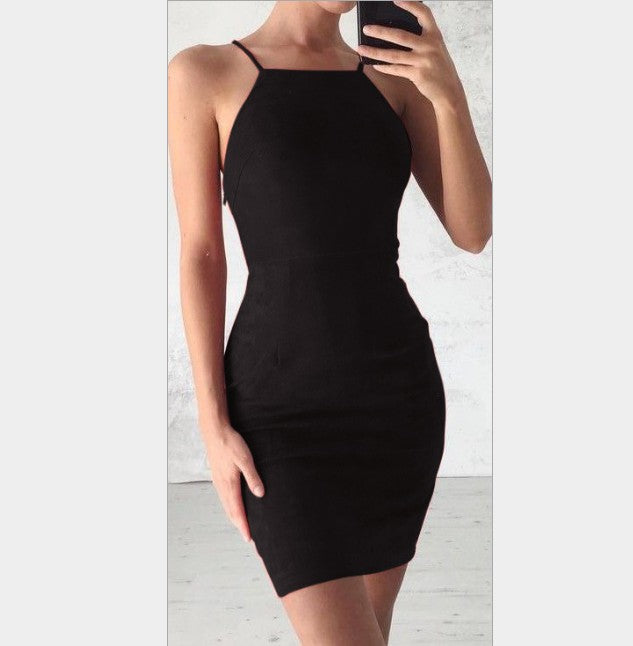 Woman wearing a fitted black sleeveless mini dress with thin straps taking a mirror selfie