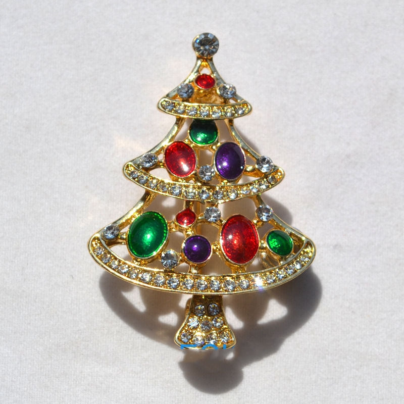 gold Christmas tree brooch with red, green, purple gems and clear rhinestones on white background