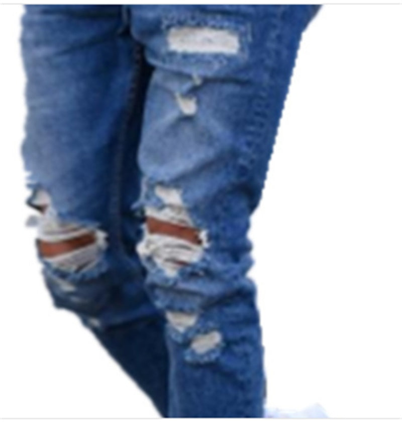 Close-up of blue distressed ripped jeans with multiple tears and frayed patches on legs