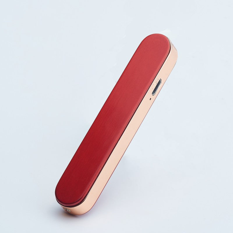Sleek red and gold electronic gadget with USB-C charging port on light gray background