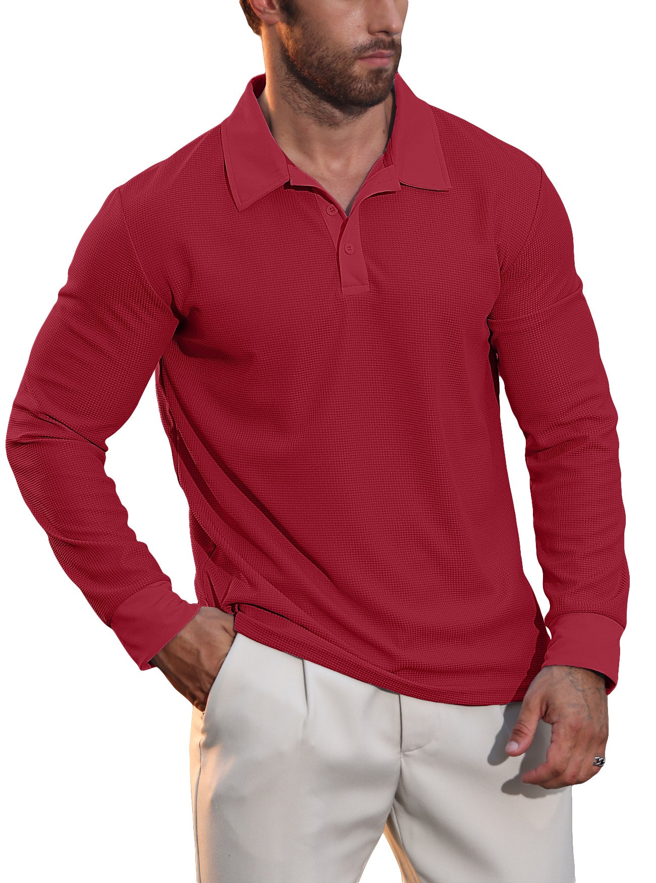 Man wearing a red long-sleeve textured polo shirt and beige pants with hand in pocket