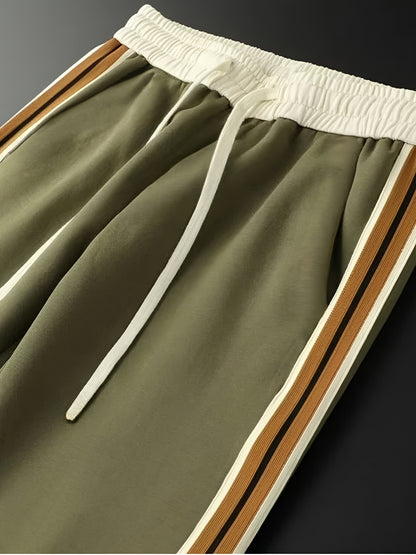 Olive green jogger pants with white elastic waistband and brown striped side panels