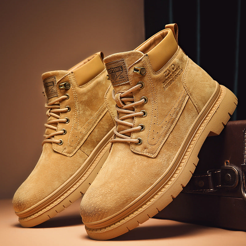 Tan suede lace-up ankle boots with rubber soles displayed on brown surface and dark background