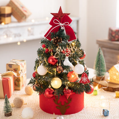 Small decorated Christmas tree with red and white ornaments, lights, and a red star on top