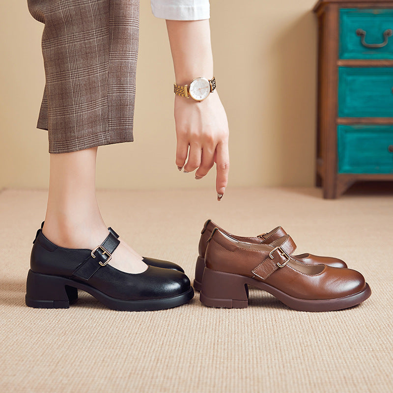 Woman wearing black Mary Jane shoes with buckle, pointing at brown Mary Jane shoes on carpeted floor