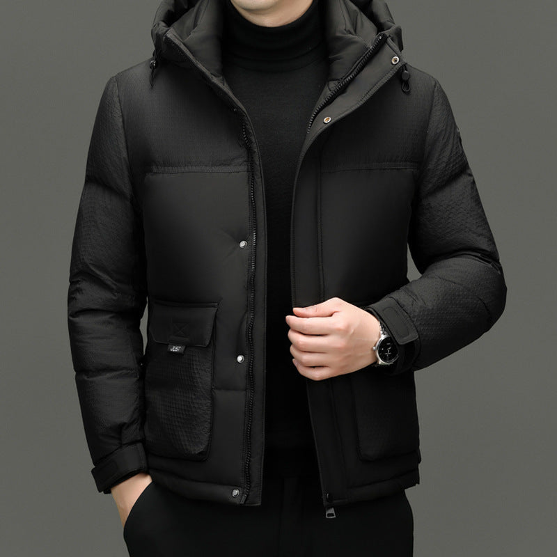 Man wearing black quilted winter jacket with hood and front pockets, black turtleneck sweater