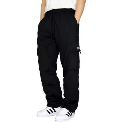 Person wearing black cargo pants with pockets and white Adidas sneakers with black stripes
