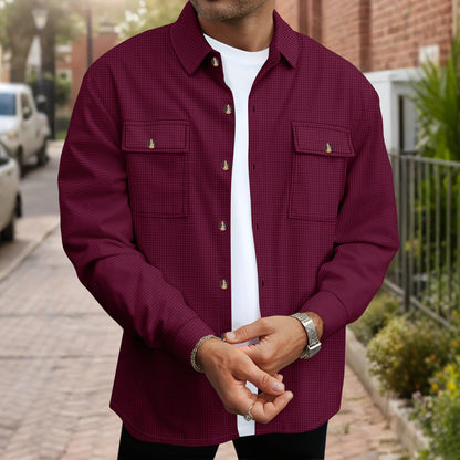 Man wearing a maroon button-up shirt with chest pockets over a white t-shirt on a city street