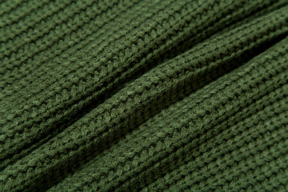 Close-up of green knitted fabric with ribbed texture and soft wool fibers