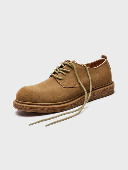 Tan suede casual lace-up shoe with textured brown sole on plain background