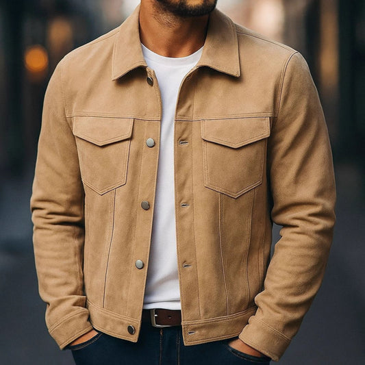 Man wearing tan suede jacket over white t-shirt and dark jeans in urban setting