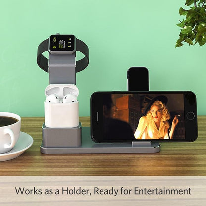 Gray charging station holding smartwatch, wireless earbuds, and smartphone on wooden table with coffee cup and plant