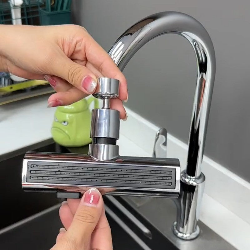 Hands installing a chrome faucet sprayer head on a modern kitchen sink with a curved spout
