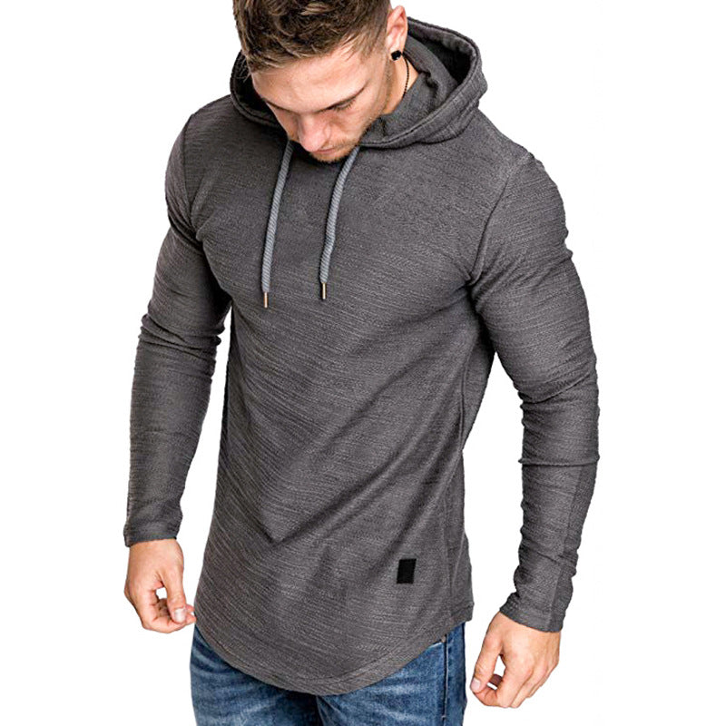 Muscular man wearing fitted long sleeve dark gray hoodie with drawstrings and blue jeans