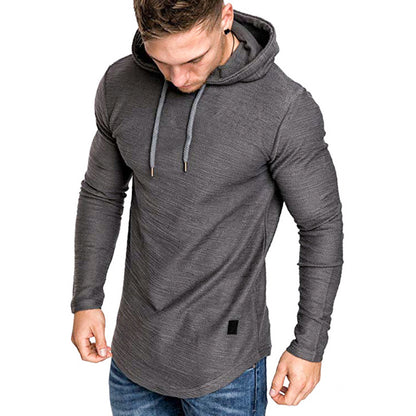 Muscular man wearing fitted long sleeve dark gray hoodie with drawstrings and blue jeans