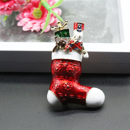 Christmas stocking brooch with red and white enamel, gold accents, toy soldier and gift design
