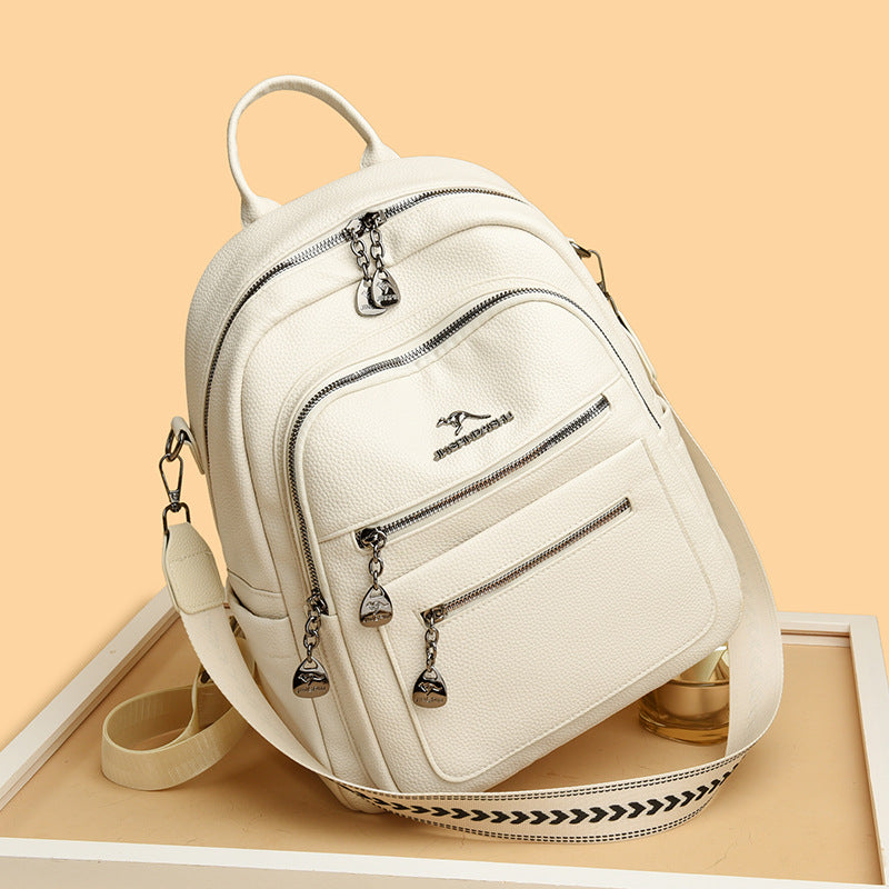 Cream white textured leather backpack with silver zippers and detachable strap on beige background
