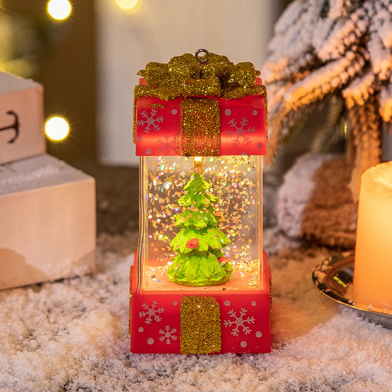 Red and gold glittered snow globe featuring a green Christmas tree, surrounded by artificial snow and warm lights