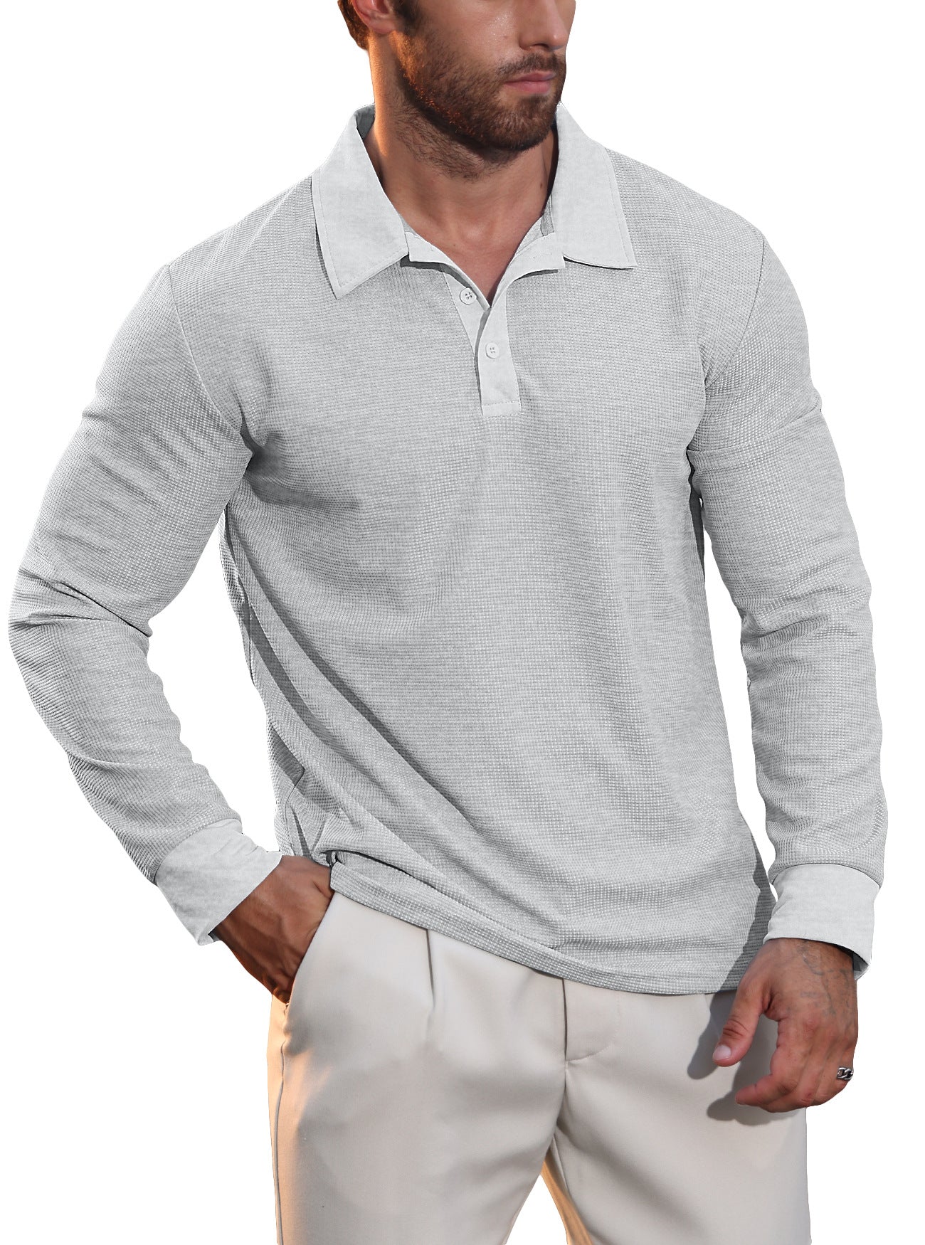 Man wearing light gray long-sleeve polo shirt and beige pants with hand in pocket