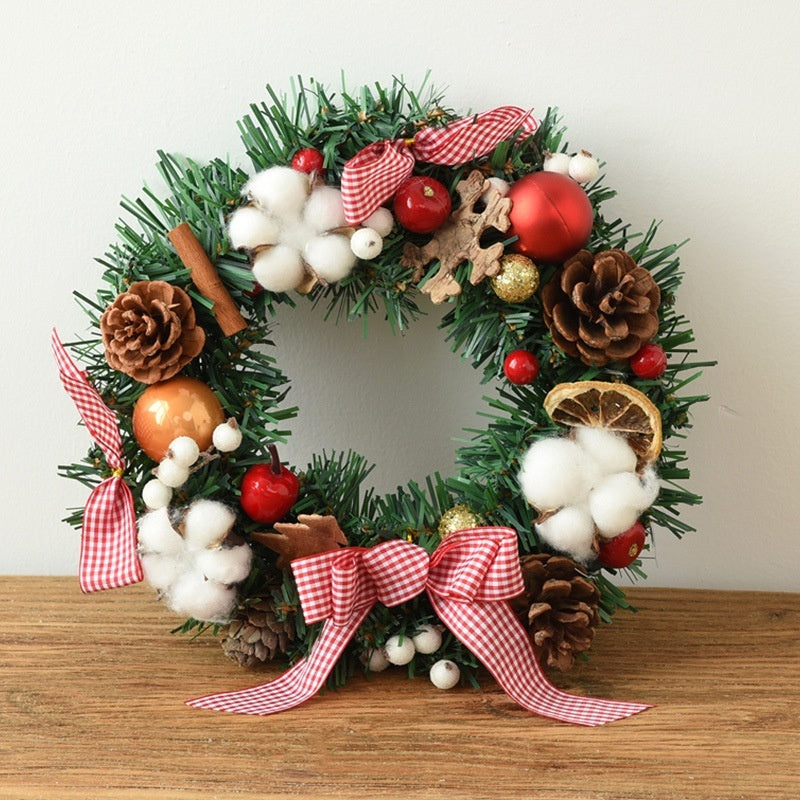 Christmas wreath with pinecones, red and gold ornaments, cinnamon stick, cotton, dried orange, and gingham ribbon