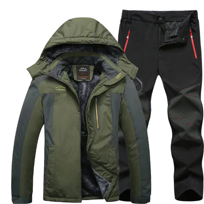 Men's green and gray insulated winter jacket with hood and black outdoor pants with red zipper accents