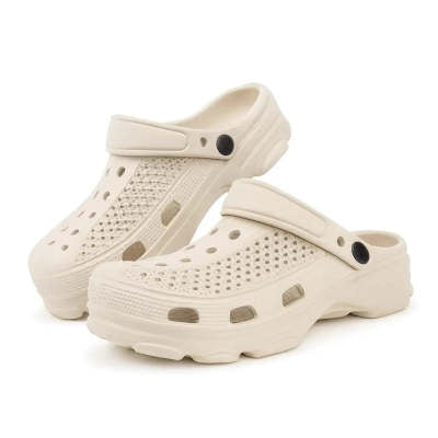 Pair of cream-colored casual slip-on clogs with ventilation holes and adjustable heel straps