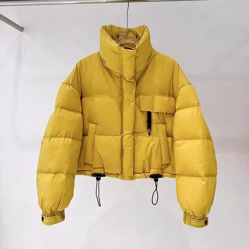 Yellow cropped puffer jacket with high collar and adjustable hem cords on hanger