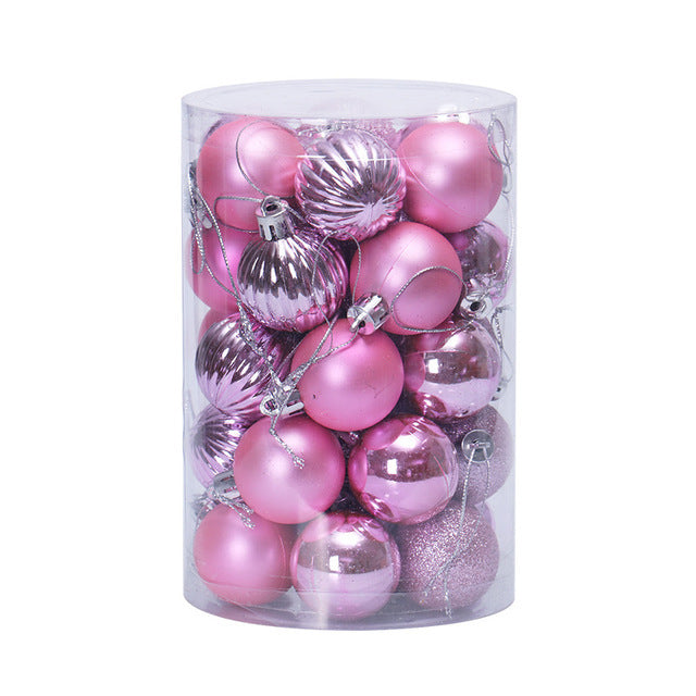 Clear cylindrical container filled with assorted pink Christmas ornaments including matte, shiny, ribbed, and glitter finishes