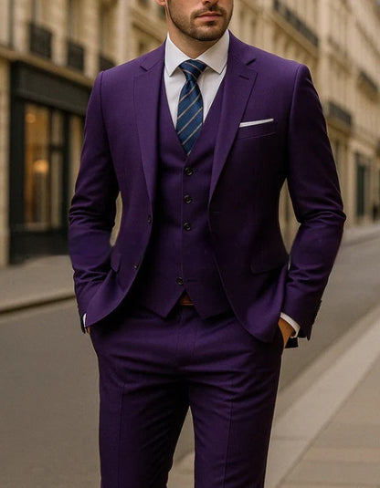 Man wearing a tailored purple three-piece suit with a blue striped tie and white pocket square on city street