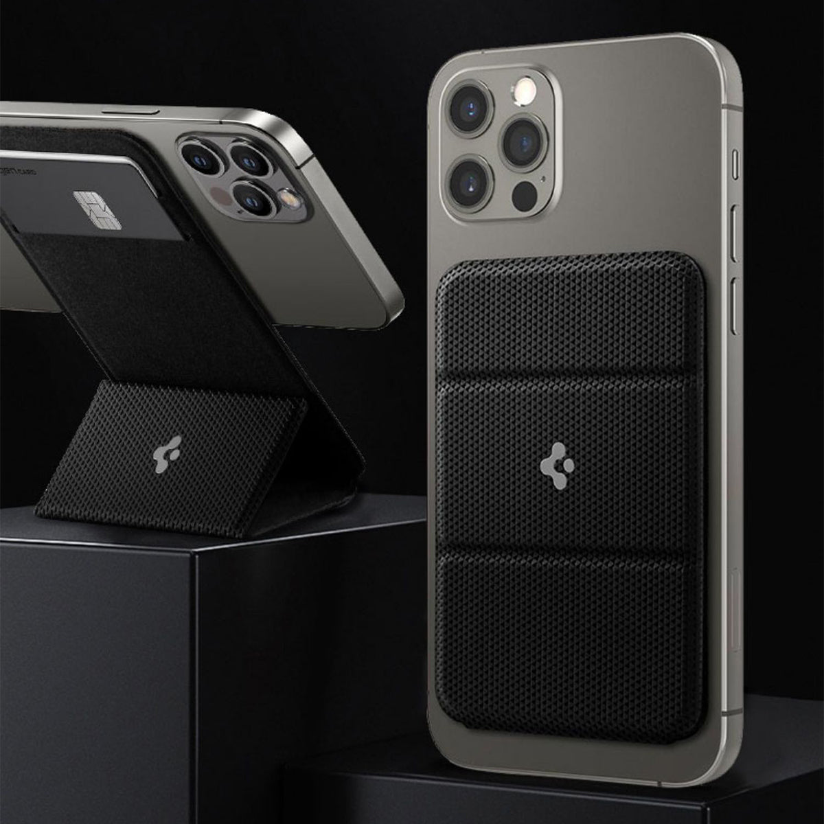 Black textured wireless magnetic phone wallet and stand attached to grey smartphones camera side up on black pedestals