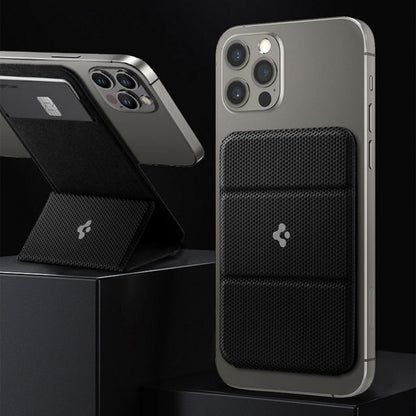 Black textured wireless magnetic phone wallet and stand attached to grey smartphones camera side up on black pedestals