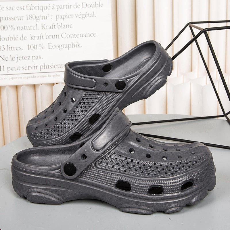 Pair of black ventilated rubber clogs with adjustable heel straps on gray surface