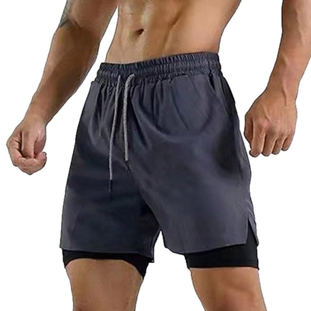 Muscular man wearing black layered workout shorts with elastic waistband and drawstring