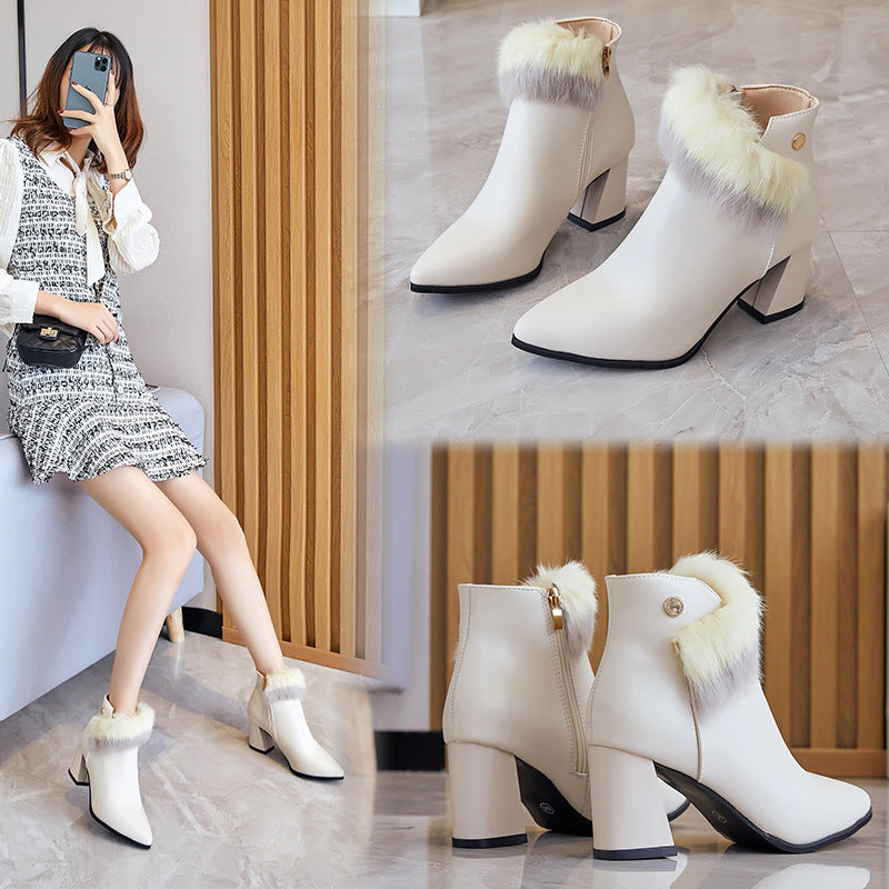 White high-heeled ankle boots with fur trim, worn by a woman sitting indoors on marble floor