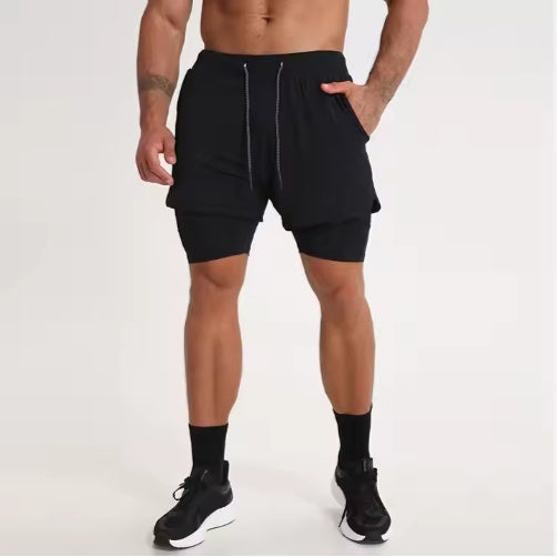 Athletic man wearing black double-layer running shorts with drawstring and compression inner layer