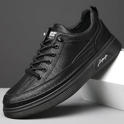Black casual men's leather sneakers with textured surface and thick sole on gray background