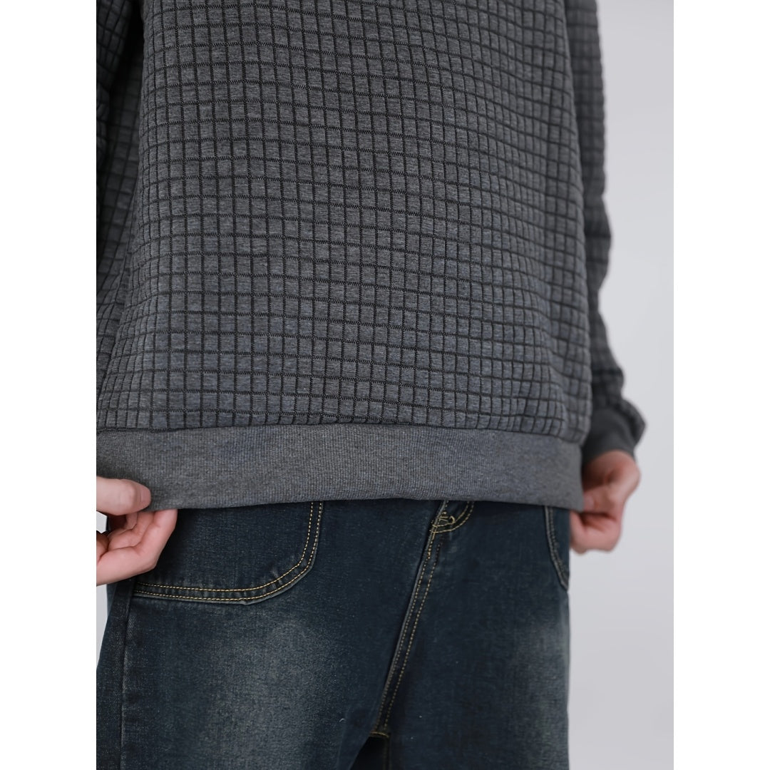 Close-up of person wearing textured gray sweatshirt and dark blue jeans with yellow stitching