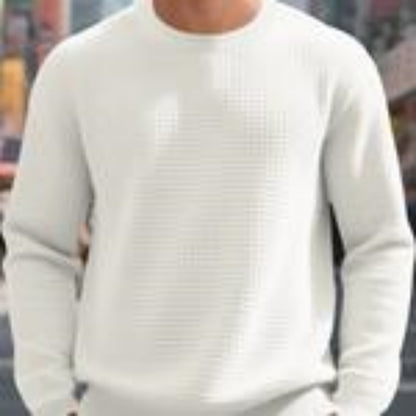 Man wearing white textured crewneck sweatshirt in casual urban setting