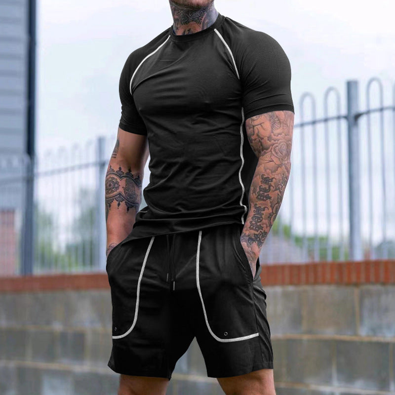 Athletic man with tattoos wearing black fitted athletic t-shirt and shorts with white piping