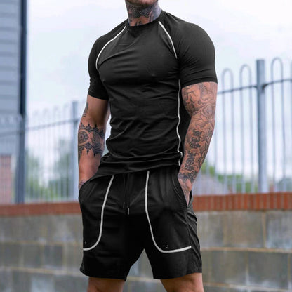 Athletic man with tattoos wearing black fitted athletic t-shirt and shorts with white piping