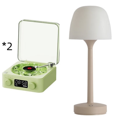 Green vintage style turntable with clear lid and beige modern table lamp
