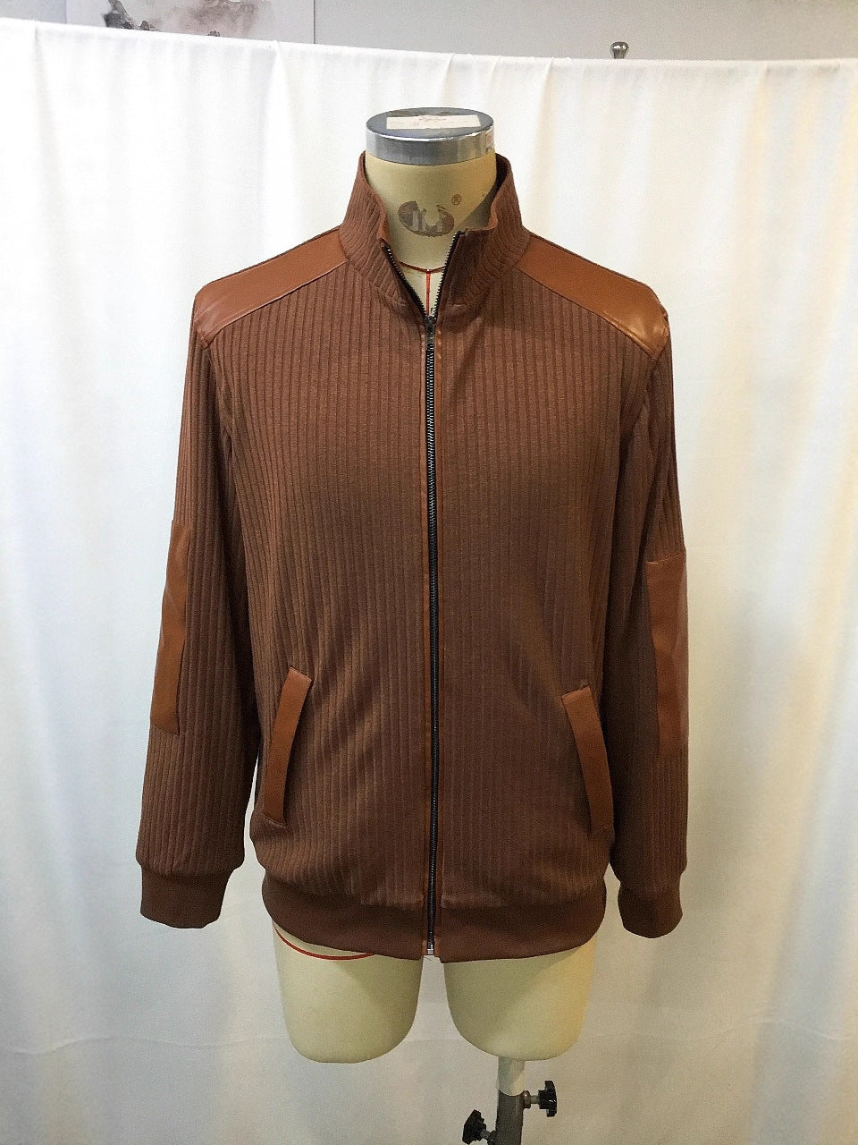 Brown ribbed zip-up men's jacket with leather accents on shoulders, elbows, and pockets displayed on mannequin