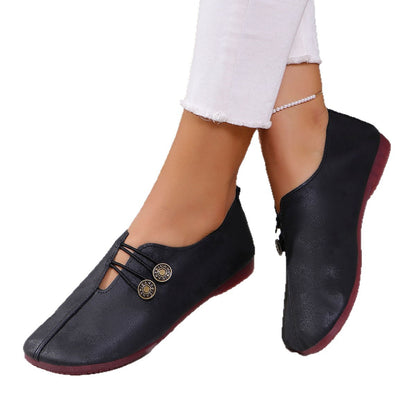 Black casual women's shoes with elastic strap and button detail worn with white frayed hem pants