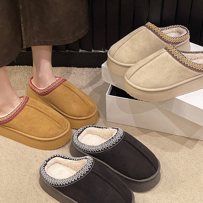 Cozy fleece-lined slip-on slippers in brown, beige, and black with decorative stitching on indoor carpet