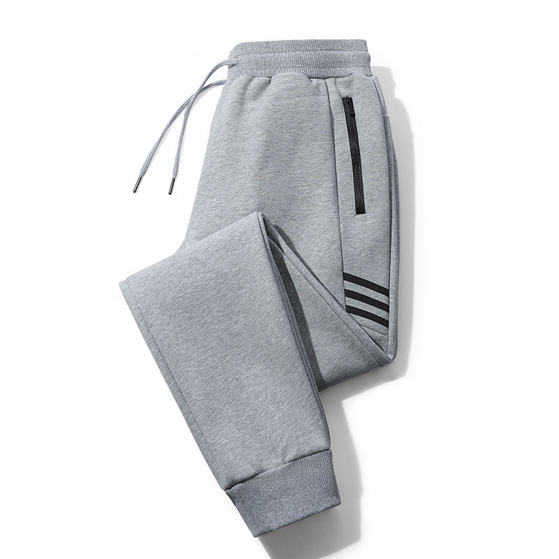 Grey fleece jogger pants with drawstring waist, zipper pocket, and black stripe detail