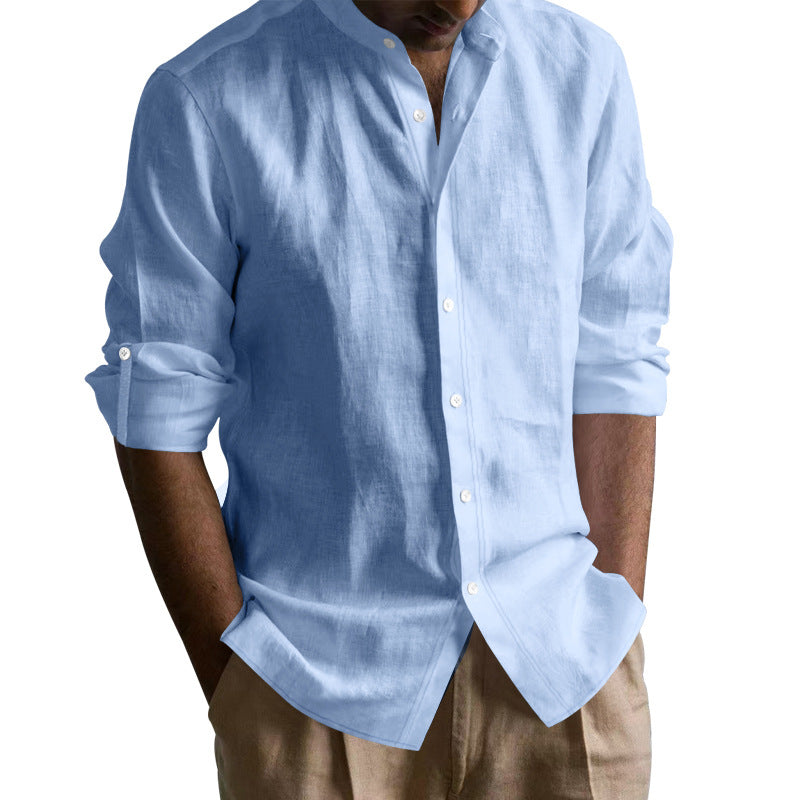 Man wearing light blue long-sleeve linen shirt with rolled-up sleeves and beige pants