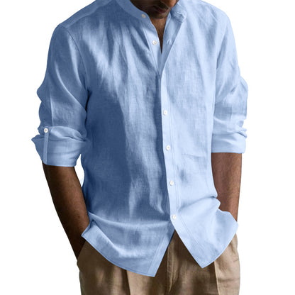 Man wearing light blue long-sleeve linen shirt with rolled-up sleeves and beige pants