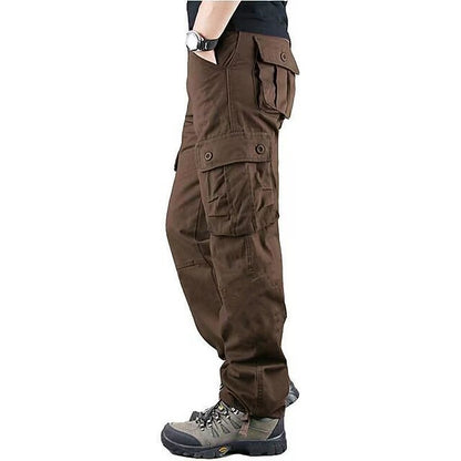 Side view of man wearing brown cargo pants with multiple pockets and hiking boots on white background