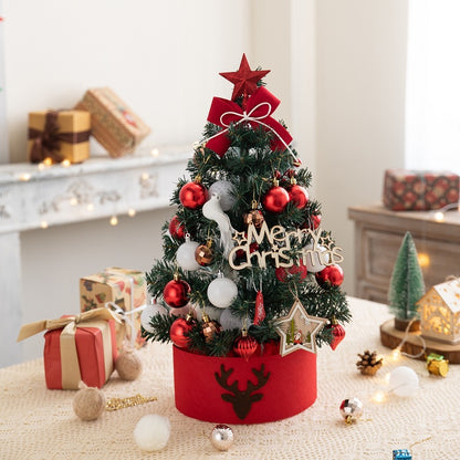 Small decorated Christmas tree with red star and ornaments on table with gifts and holiday decor